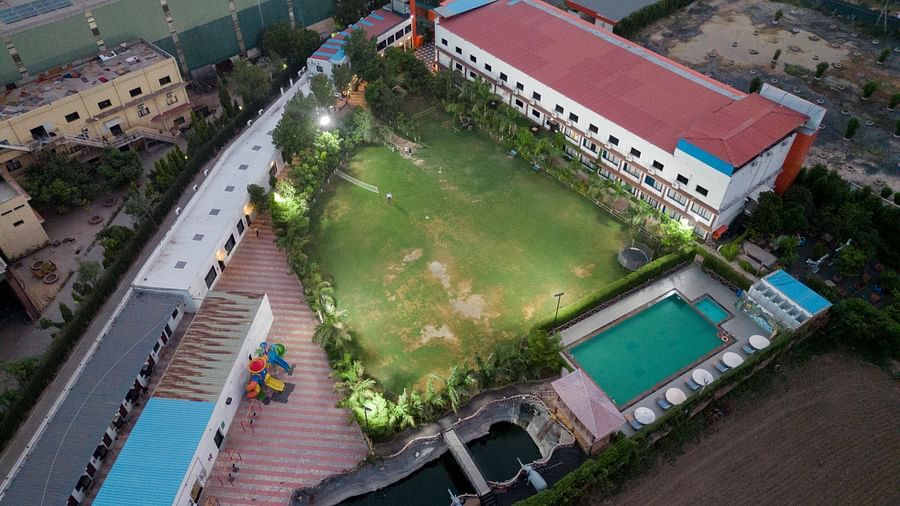 Aerial shot of Clarks Safari Kheda's central structure, with a large open field, a swimming pool, and other ancillary buildings.