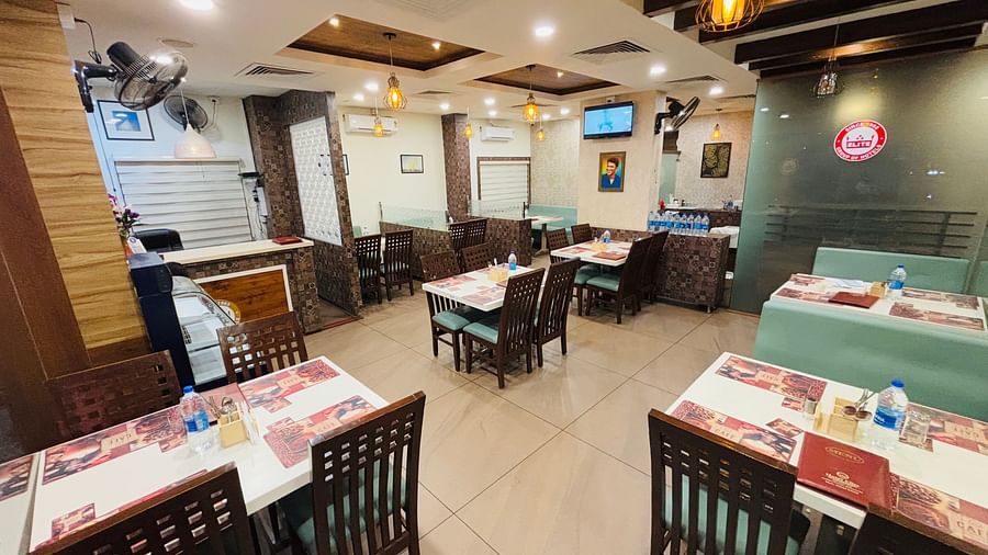 The side view of Elegant restaurant interior with wooden accents and ambient lighting at Hotel Dr Rajkumar International.