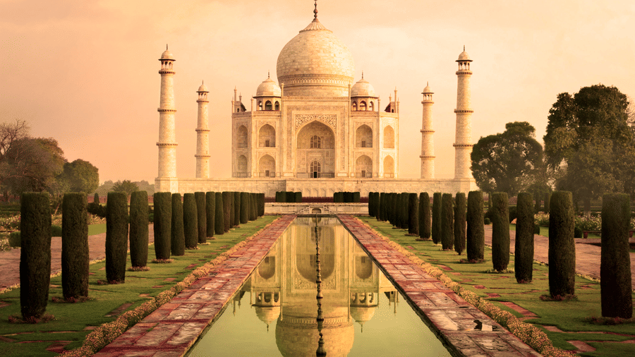 Taj Mahal, Agra featuring a pathway with trees on either side and a pool in between leading to the monument