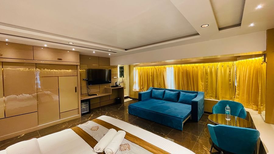 A tv wall mounted, sofa, king bed and sofa bed inside Executive Suite - Home2 Renaissance Club Hotel