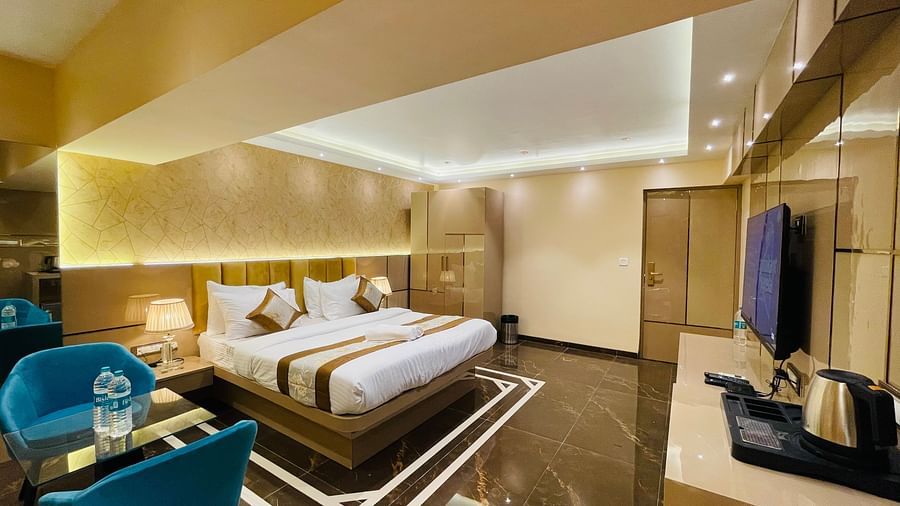 Another view of the king bed next to sofas inside Suite - Home2 Renaissance Club Hotel