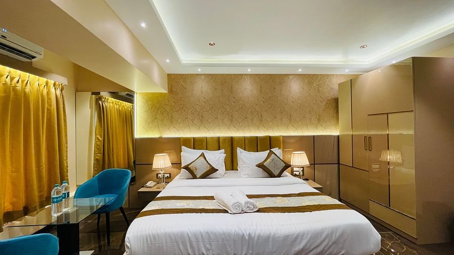 Front view of the king bed next to sofas inside Suite - Home2 Renaissance Club Hotel