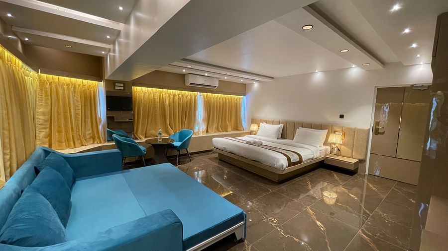 Side view of the sofa bed opposite the king bed inside Executive Suite - Home2 Renaissance Club Hotel