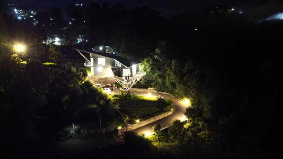 Night-view of a villa situated in a forest featuring well build roads, and warm lighting at Ibex Resorts, Coonoor (Tapas).