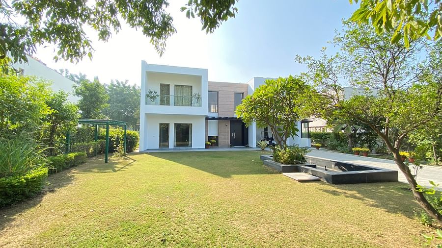 Facade view of Pranavam Villa with a manicured lawn in front of it - Karma Lakelands.