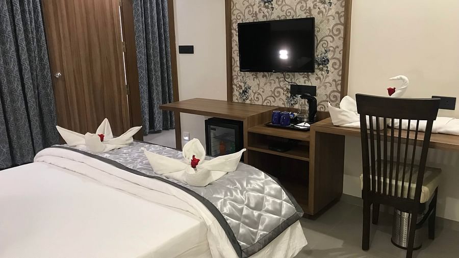 Suite With Breakfast room featuring a bed, desk, chair and TV | Kyriad Hotel, Solapur