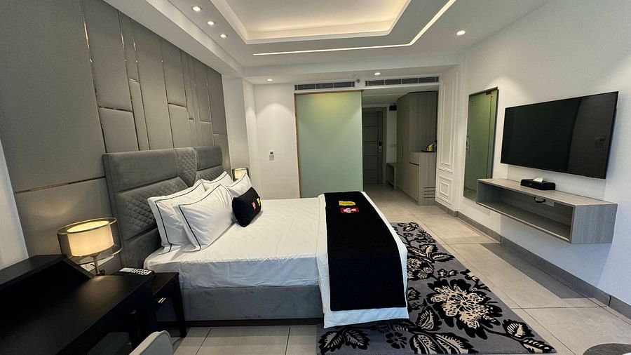an image of a deluxe room with a television and a wardrobe at Mastiff Select Mandavya Dharamkot, McLeodganj