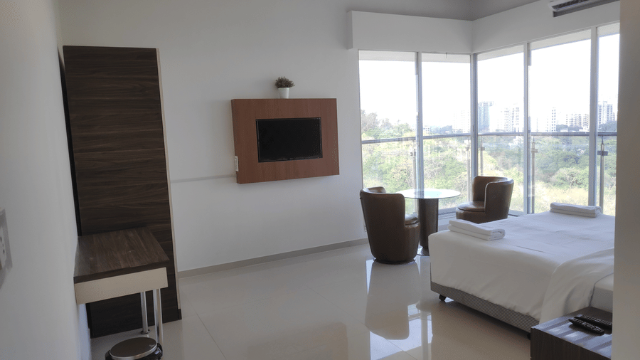 A full view of a bedroom with glass windows in a 3 BHK service apartment in Chandivali