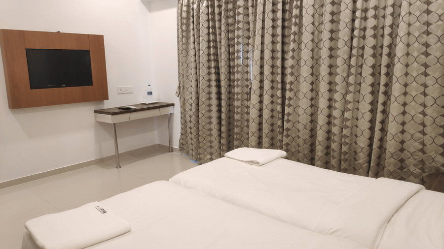 A view of the bedroom with twin beds in a 2 BHK service apartment in Mumbai