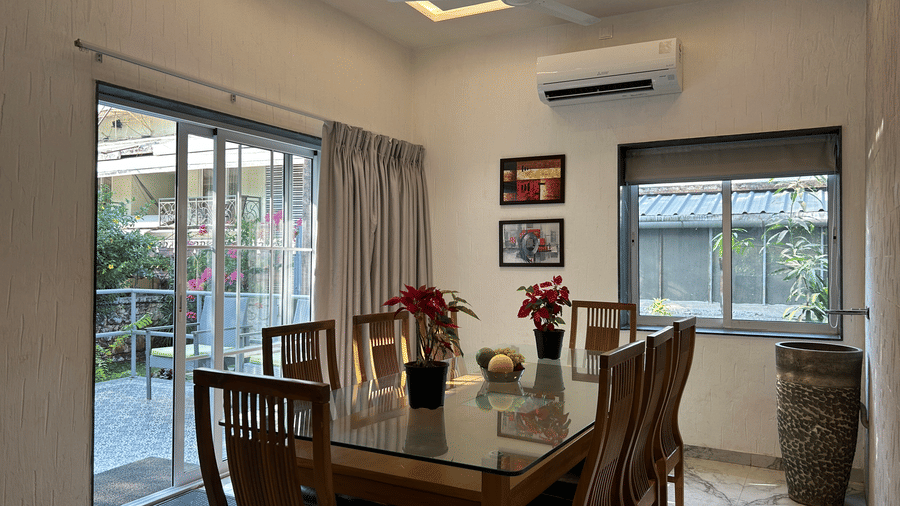 A sophisticated dining area with a polished wooden table, elegant chairs, and large glass windows – Maxxvalue Klub Klass Villa, Lonavala.