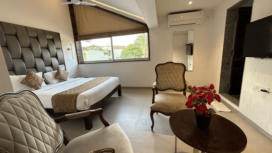 Stylish bed suite with a cushioned headboard, elegant decor, and a cosy seating area – Maxxvalue Klub Klass Villa, Lonavala.