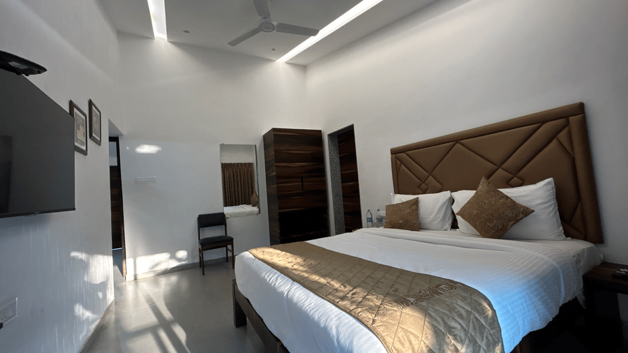 Bedroom with a modern design, featuring a king size bed, stylish lighting, and wooden furnishings – Maxxvalue Klub Klass Villa, Lonavala.