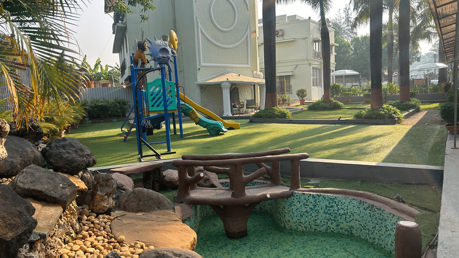 Scenic outdoor area with a play zone and a small pond, surrounded by lush greenery – Maxxvalue Klub Klass Villa, Lonavala.