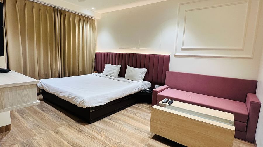 Premium Bedroom with white beddings, mahognagy headrest and mathcing sofa - Hotel Morya, Bhopal