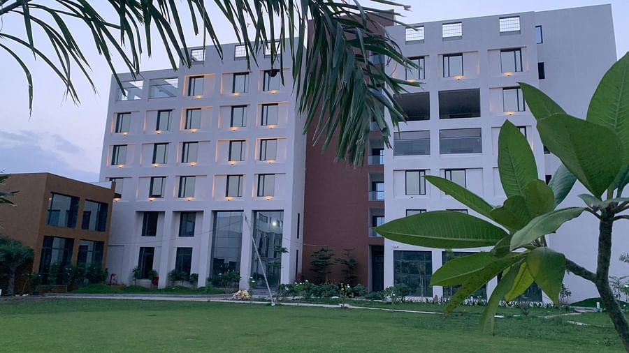 Image of the Facade of Pride Resort Ambaji  taken from it's garden hence a little bit of the garden is visible too