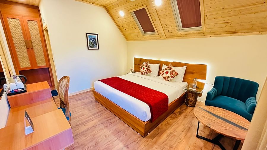 a double bed with windows above the roof and red bed runner on it inside one of the rooms - Samsara Luxury Cottages & Spa