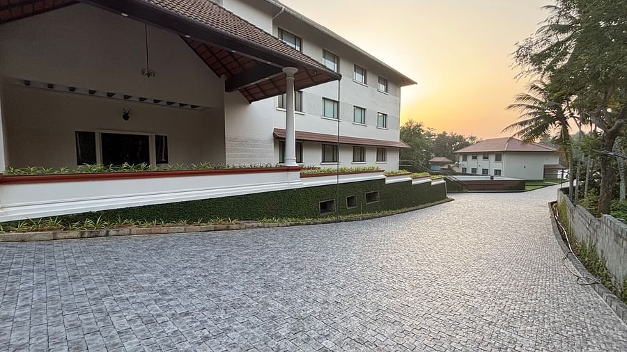 A pebbled driveway leading to the entrance of Still Waters, Varkala under a dusky sky.