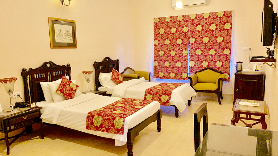 Twin beds with red blankets and red pillow covers at the Junior Suite at hotel Suryaa Villa Jaipur