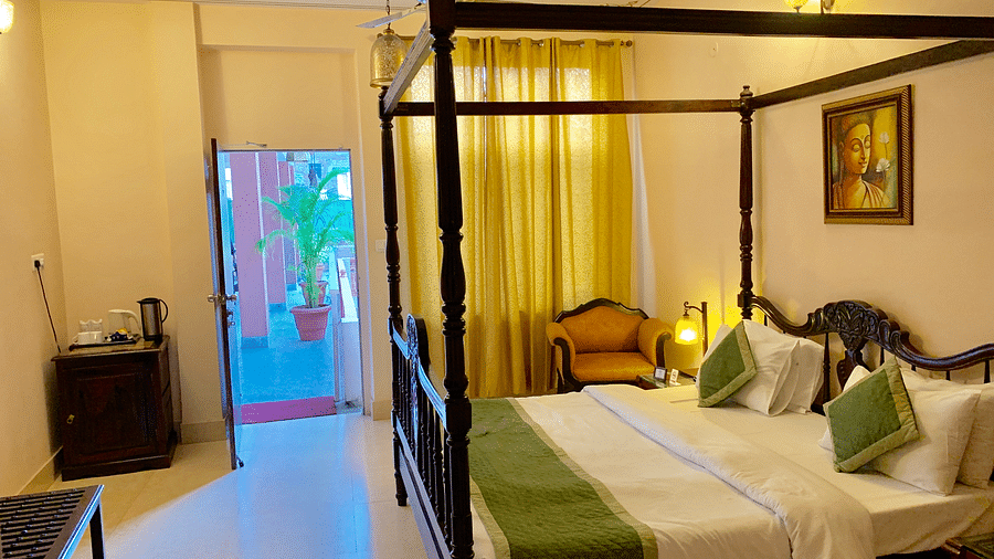 Double bed with green blanket and green pillow covers in Juinor Suite at hotel Suryaa Villa Jaipur