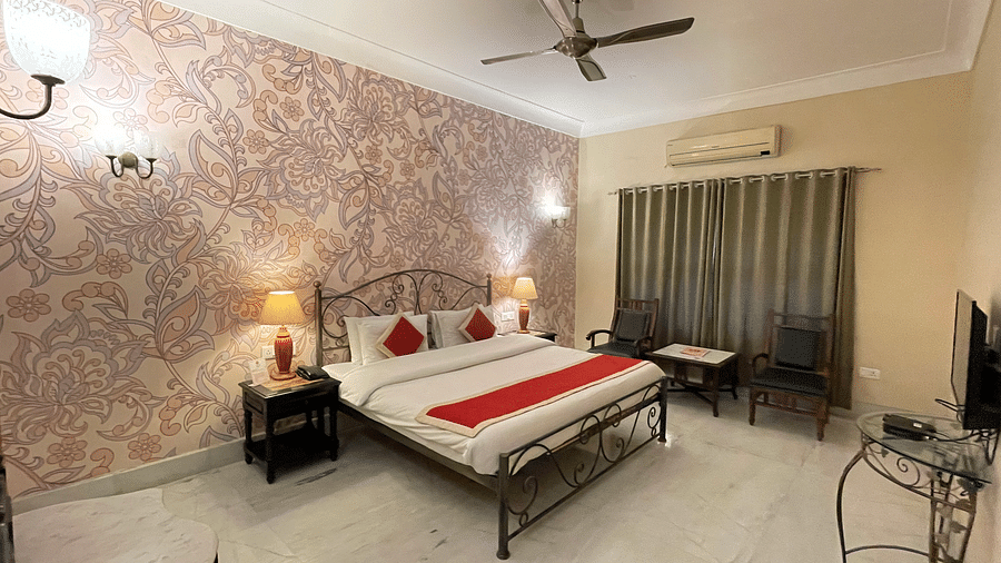 Double bed with red blanket and red pillow covers in Juinor Suite at hotel Suryaa Villa Jaipur