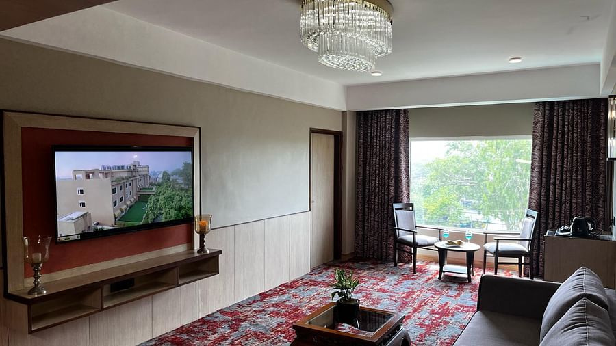 Hotel suite with comfortable seating and large TV at The Lalita Grand