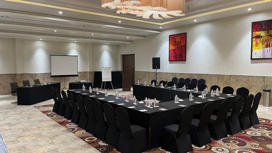 Conference hall with black chairs and projector at Lalita Grand 