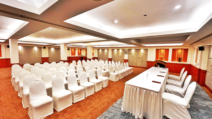 Banquet hall set up in theatre-style seating with white chairs and a head table at The Residency Karur, ideal for conferences and formal gatherings
