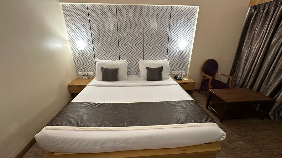 Double bed room with bed side table and seating area at VITS Kamats Resort, Silvassa