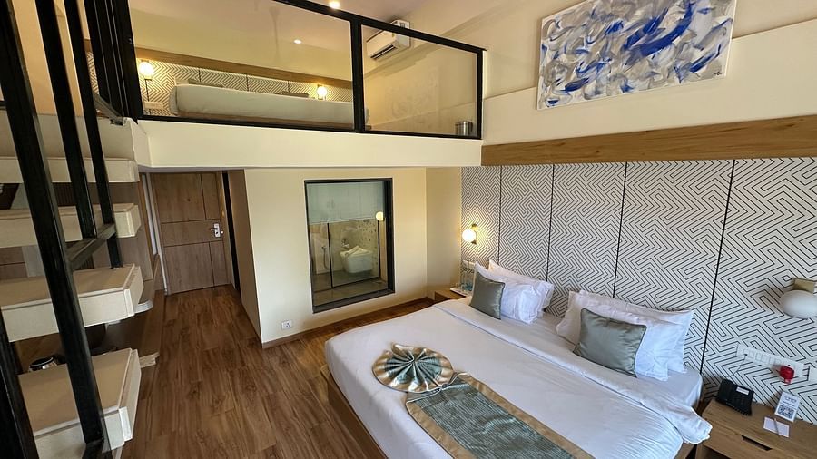 Kind size bedroom with see through bathroom, bedside table, and a second deck at VITS Kamats Resort, Silvassa