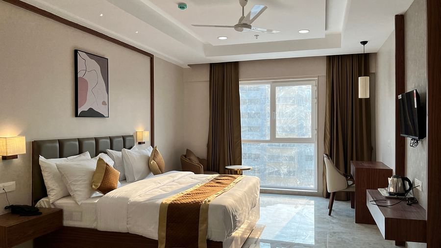 a bedroom at VITS Satyajeet Karad featuring a bed, work desk and television facing a window