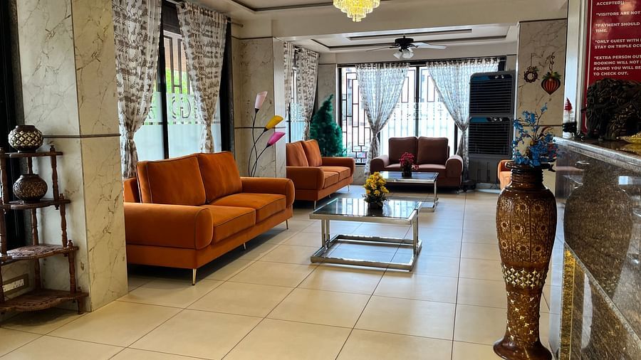 Another angle of the hotel lobby with orange couches placed in front of coffee tables at VITS Select Kharadi, Pune.