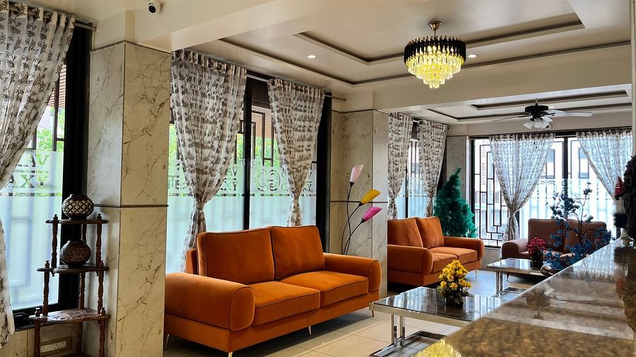 A close up shot of the hotel lobby with orange couches placed in front of coffee tables at VITS Select Kharadi, Pune.