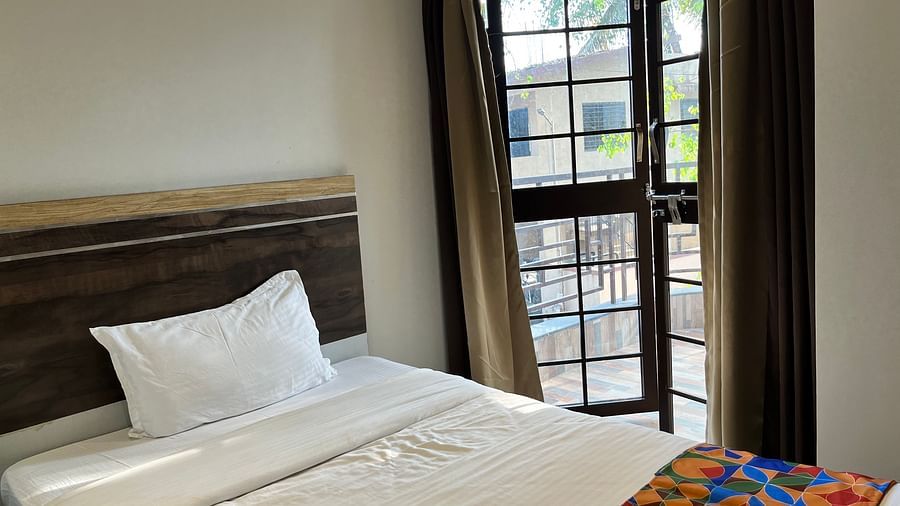 A close up shot of a bed near a window in our hotel room at VITS Select Kharadi, Pune.