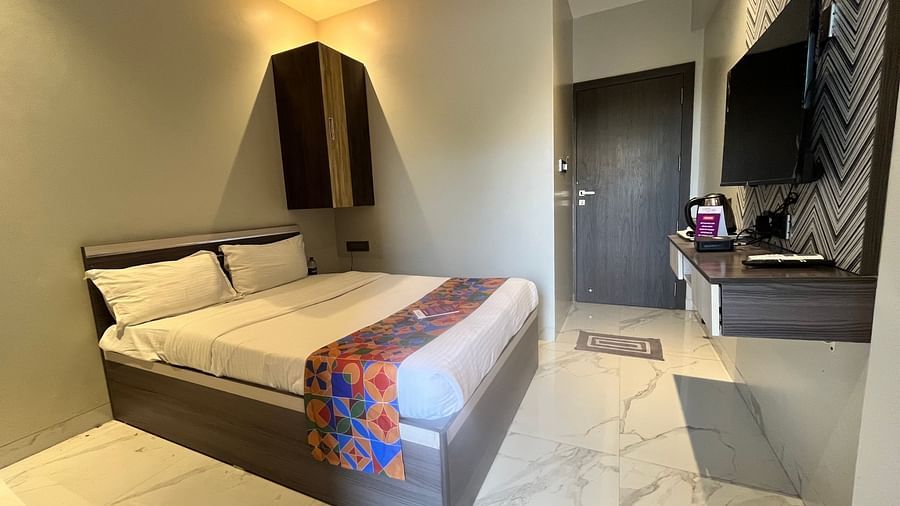 A hotel bedroom with a large bed, a television and a cupboard at VITS Select Kharadi, Pune.