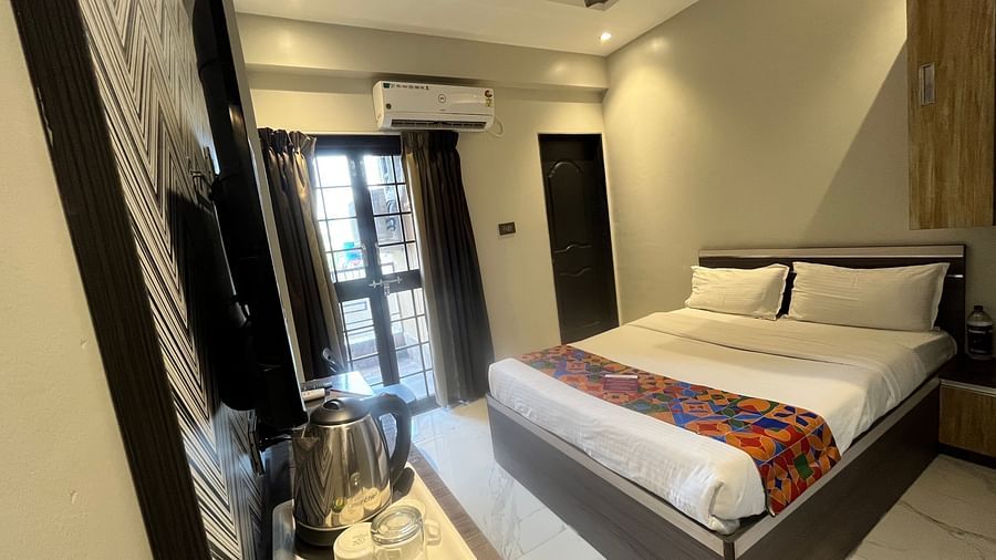 A hotel bedroom with a large bed in front of a wall mounted television and a wall mounted air-conditioner at VITS Select Kharadi, Pune.