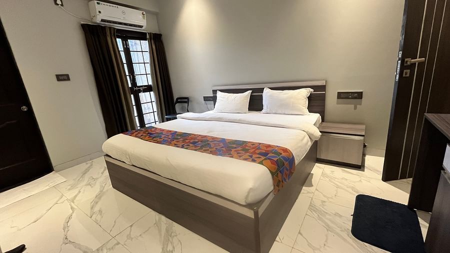 A hotel room with a large bed placed under ambient lamps lighting the room at VITS Select Kharadi, Pune.