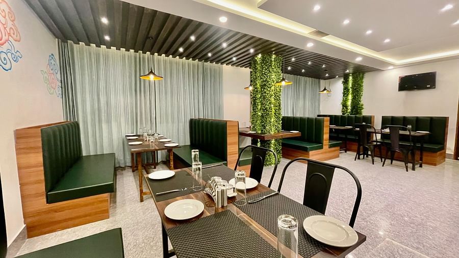 Chairs and cutlery arranged on dining tables in a well-lit enclosed space | Voyage The Royal Retreat, Gangtok