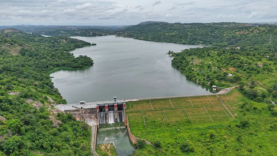Water body with a man made gate covered by greenery on all sides.