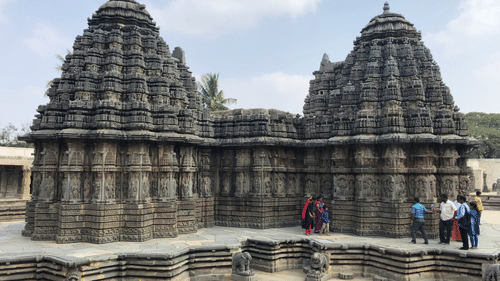 people standing under a temple under blue skies