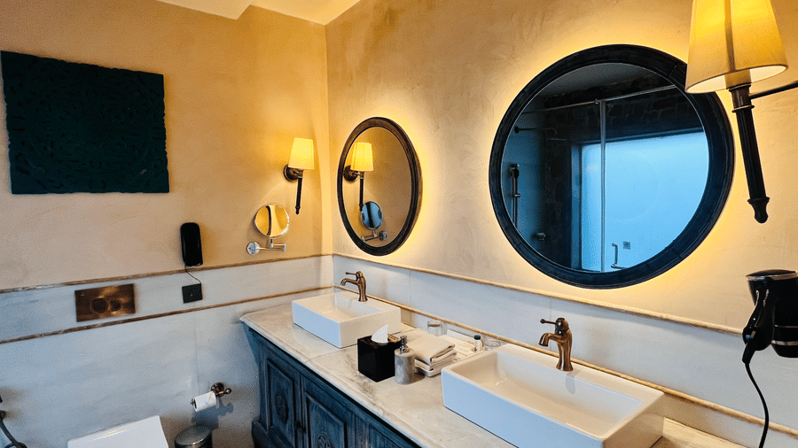 Premium Deluxe Room bathroom vanity at Juna Mahal, Ranthambore with twin sinks, mirror lighting and stylish interiors for added comfort