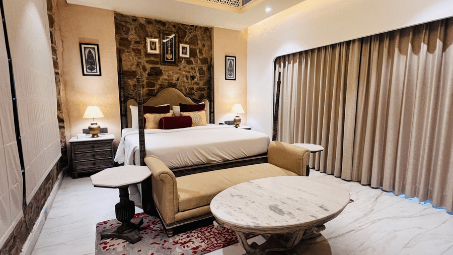 Premium Deluxe Room bedroom at Juna Mahal, Ranthambore featuring king bed, ambient lighting, artwork and refined interiors