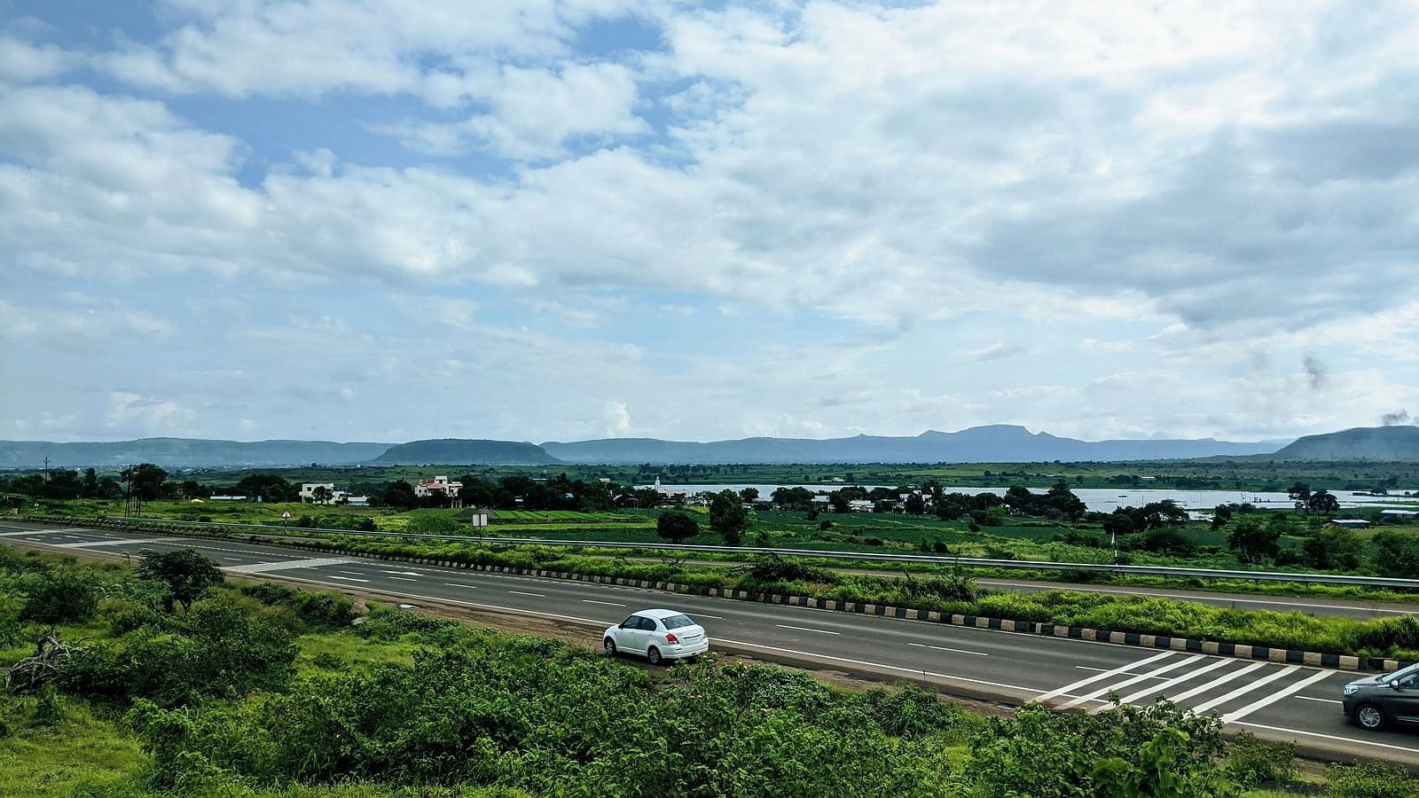A road stretches through a landscape with greenery.