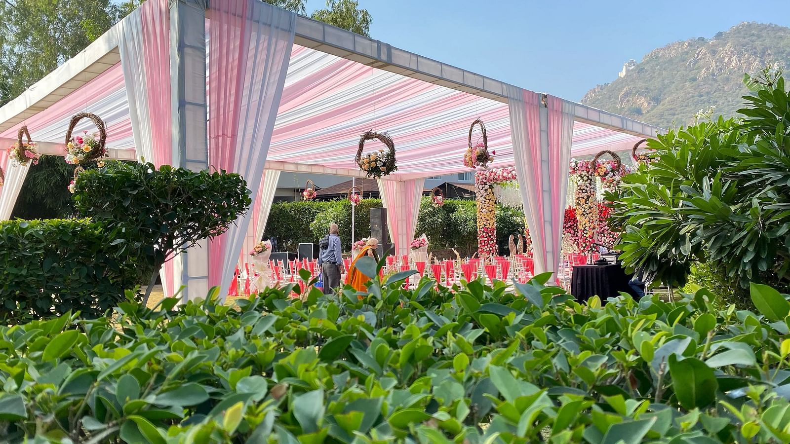 Tent structure with greenery in the foreground.