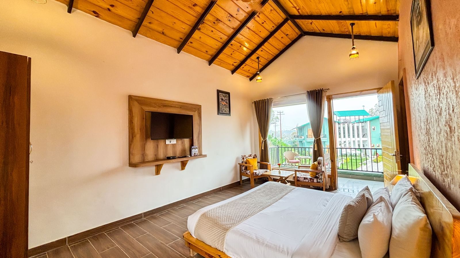 Bright resort room with wooden ceiling, modern decor, and large windows offering scenic views.