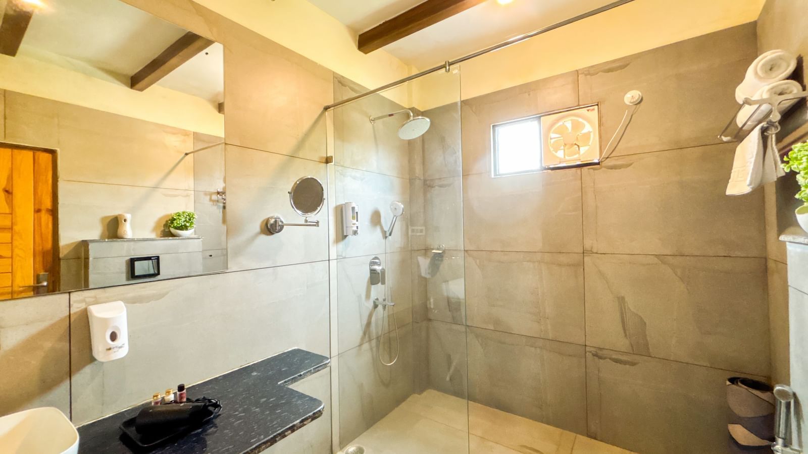 Modern bathroom with glass shower enclosure and sleek fittings at Corbett Nirvana Resort.