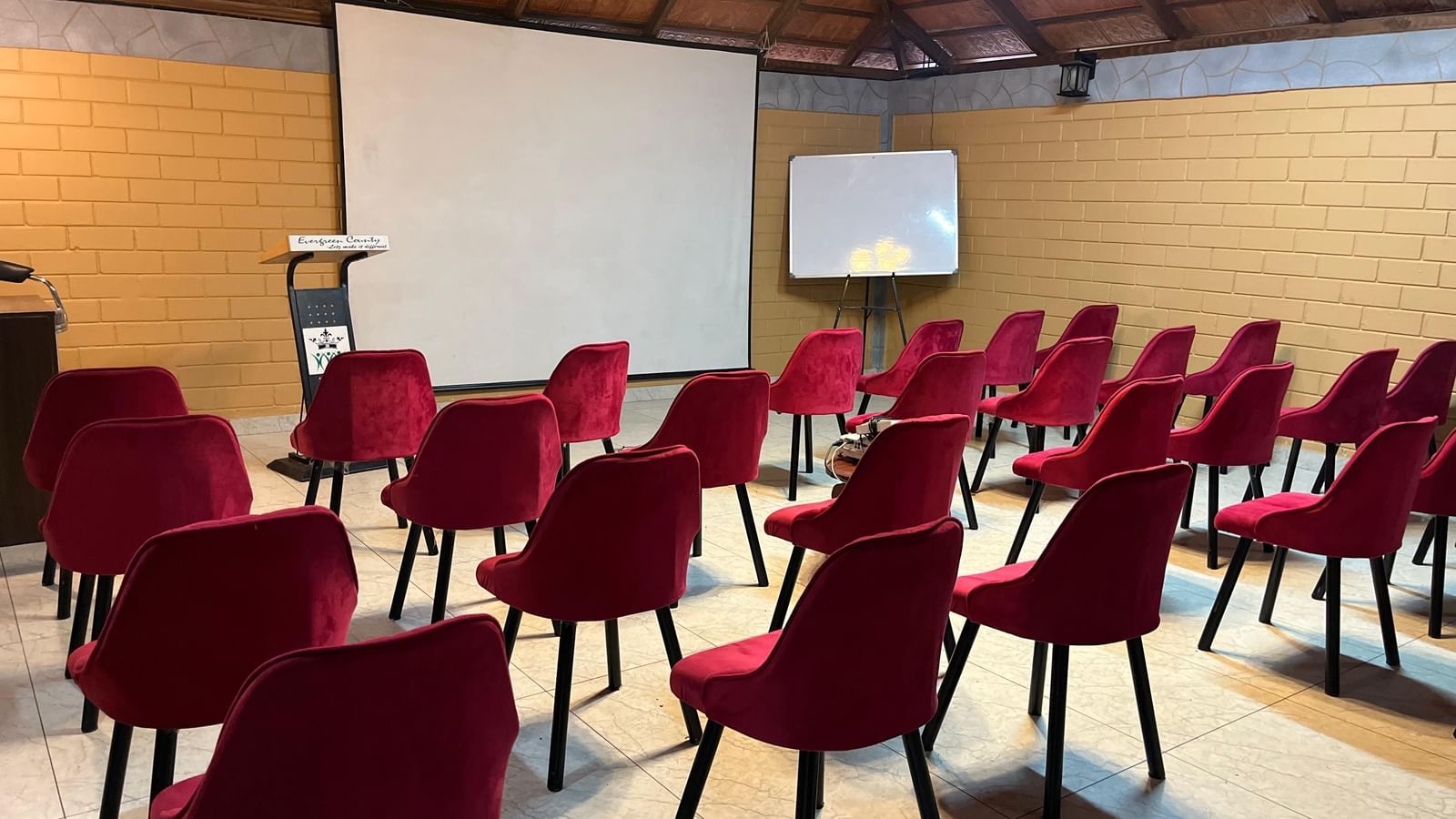 Robusta Meeting Hall at Evergreen County, Coorg with burgundy velvet chairs and projector facilities for corporate events