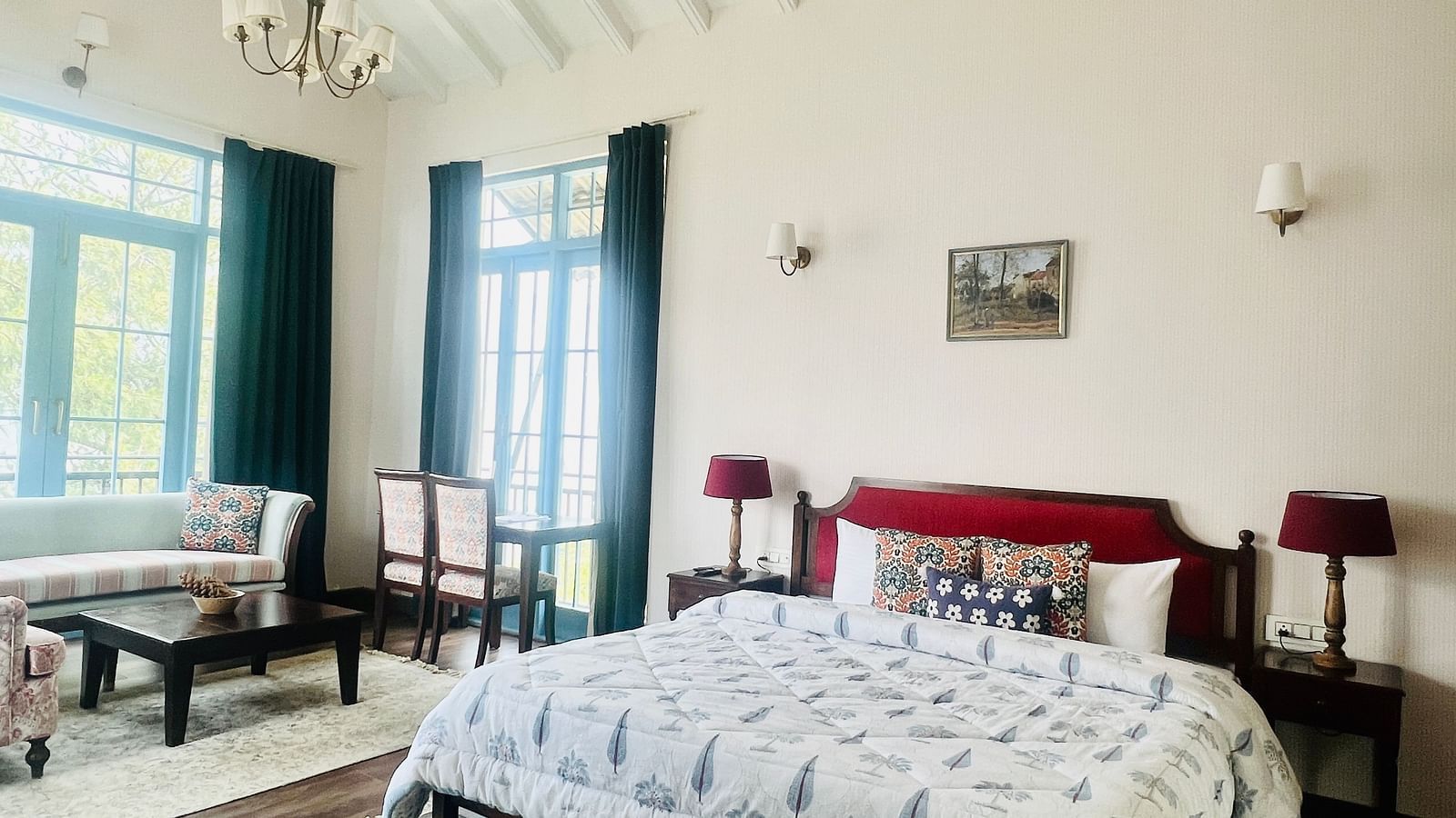 Bright hotel room with wooden floor, blue drapes, and comfortable bed | Faraway Cottages, Auli