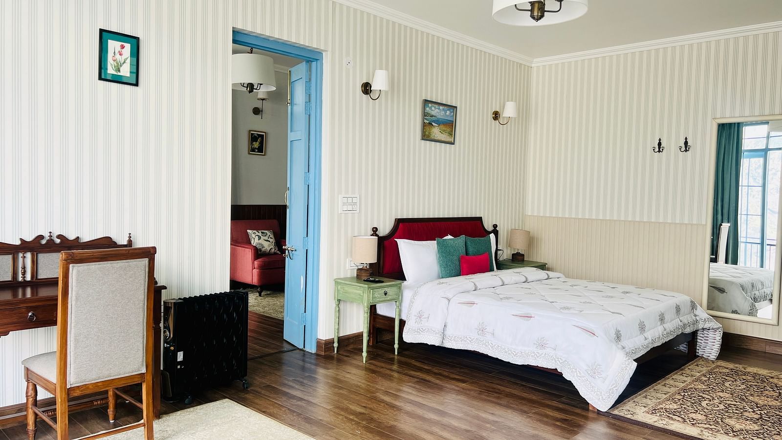 An image of a suite with bed, a table and chair, and bathroom attached | Faraway Cottages, Auli