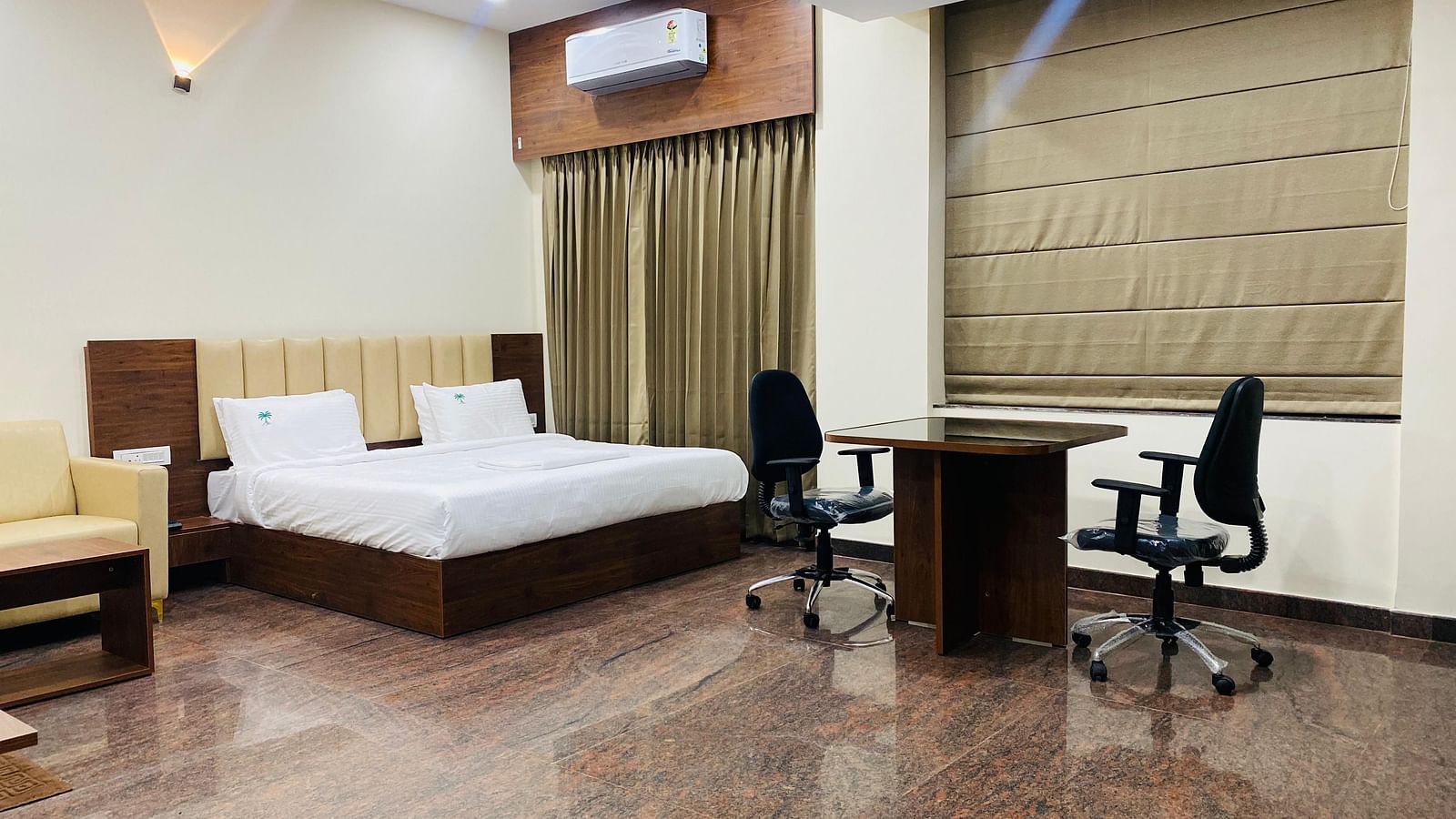 Premium suite with king bed, work desk, and warm tones for business or leisure stays at Hotel Sahara Tree.
