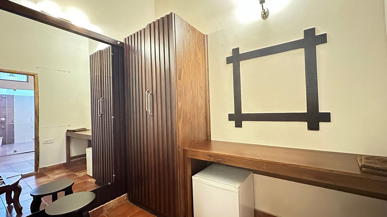 a room with a standing desk and a stool and a large mirror on the wall - Kadkani River Resort, Coorg